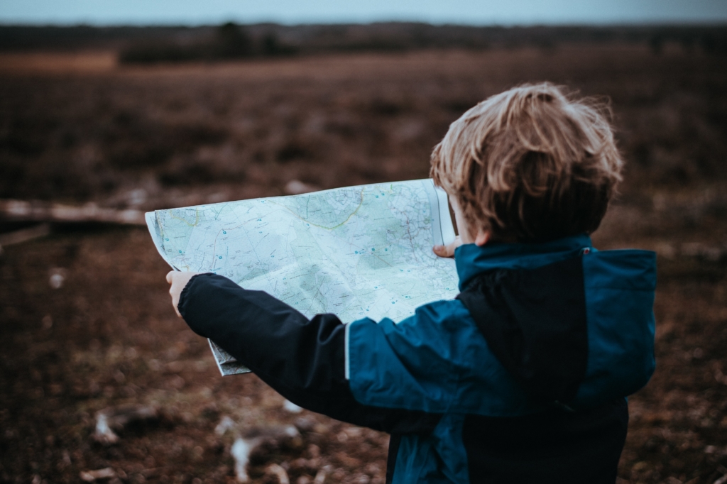 young boy reads map