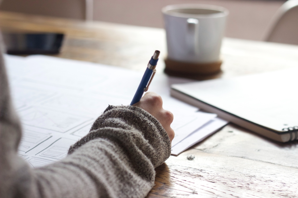 hand using pen to write on paperwork